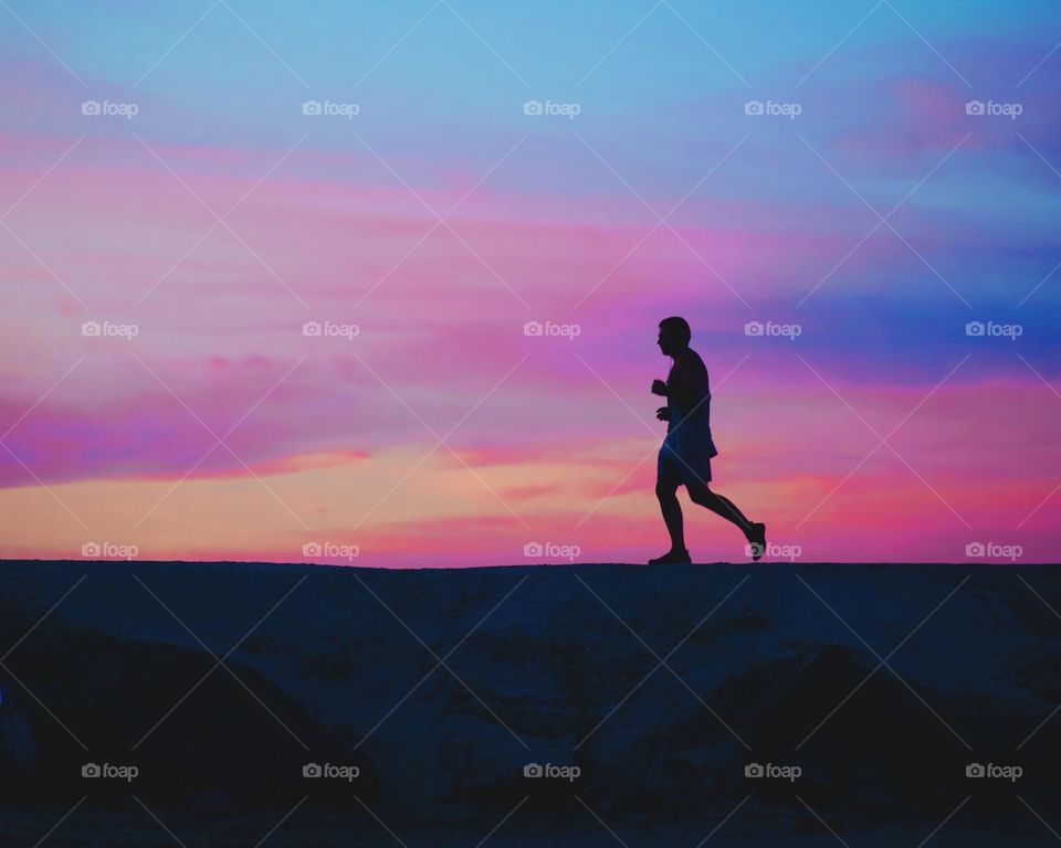 Silhouette of a man running during sunset