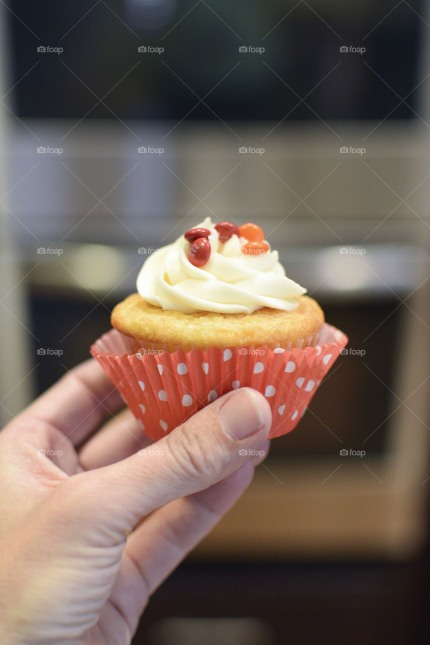 Hand holding a cupcake in the kitchen 