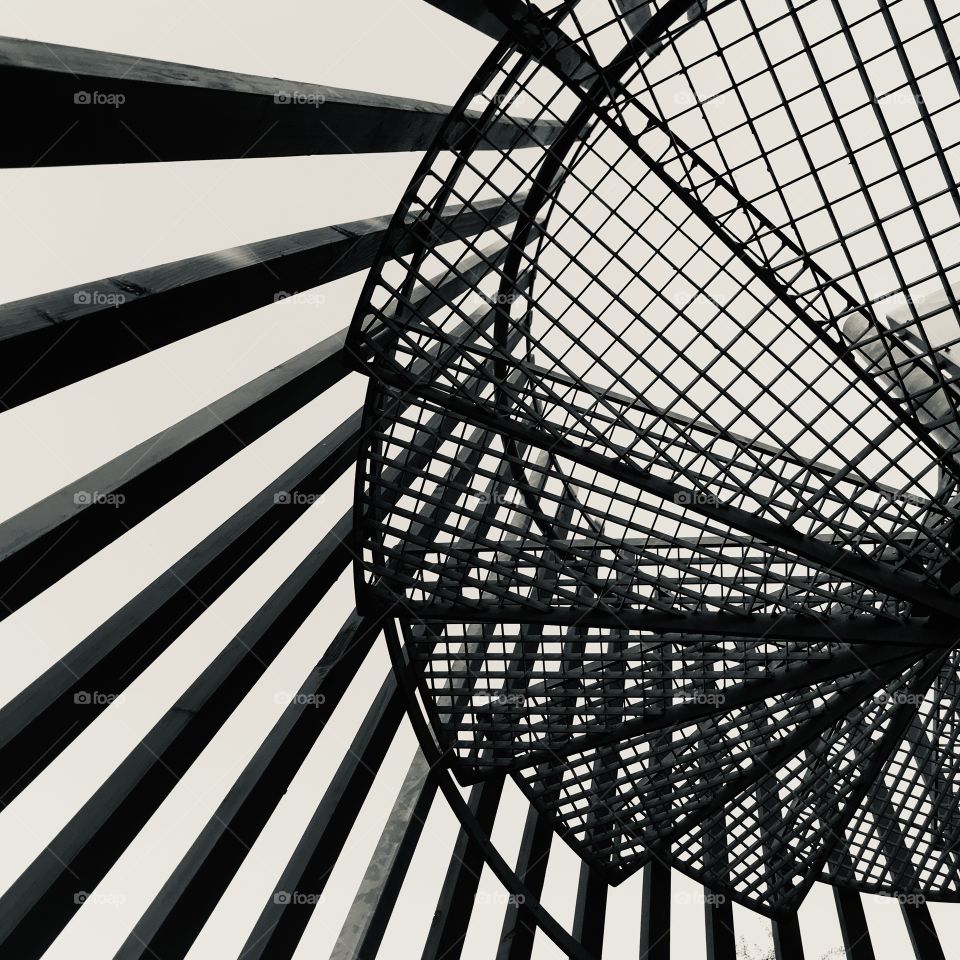 
Low angle view: Spiral staircase photographed from below set against the sky.