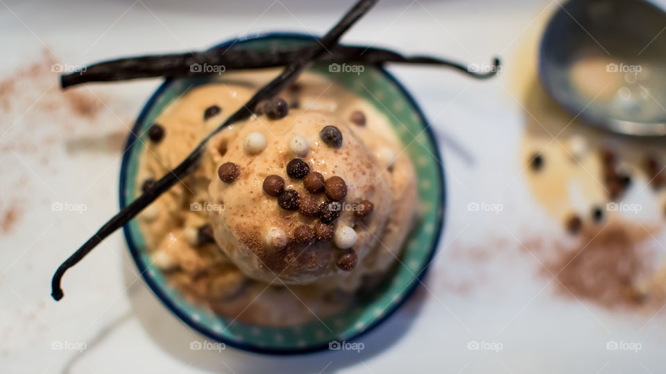 Ice cream in bowl with fresh vanilla bean pods