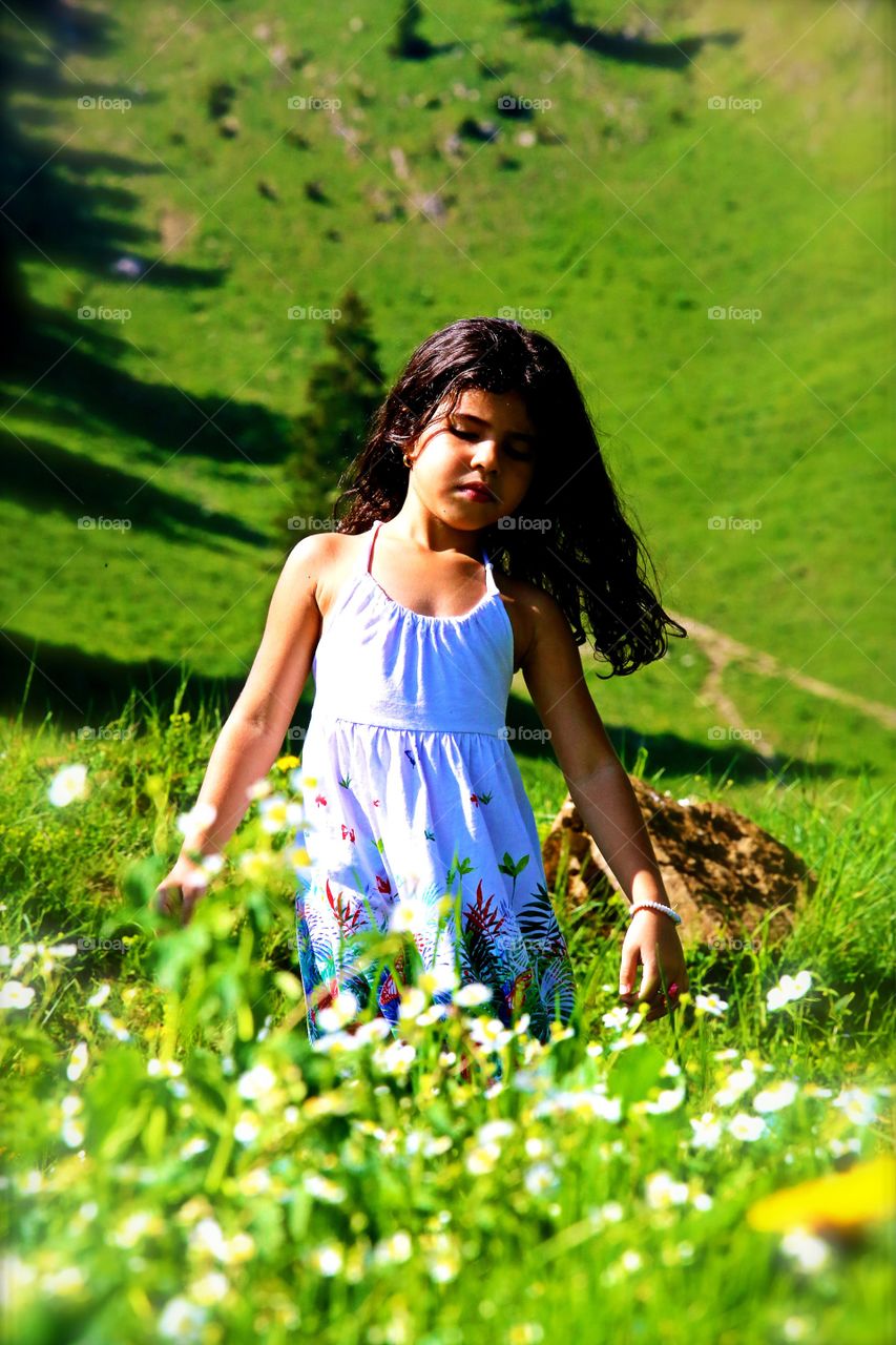 Little girl standing flower field