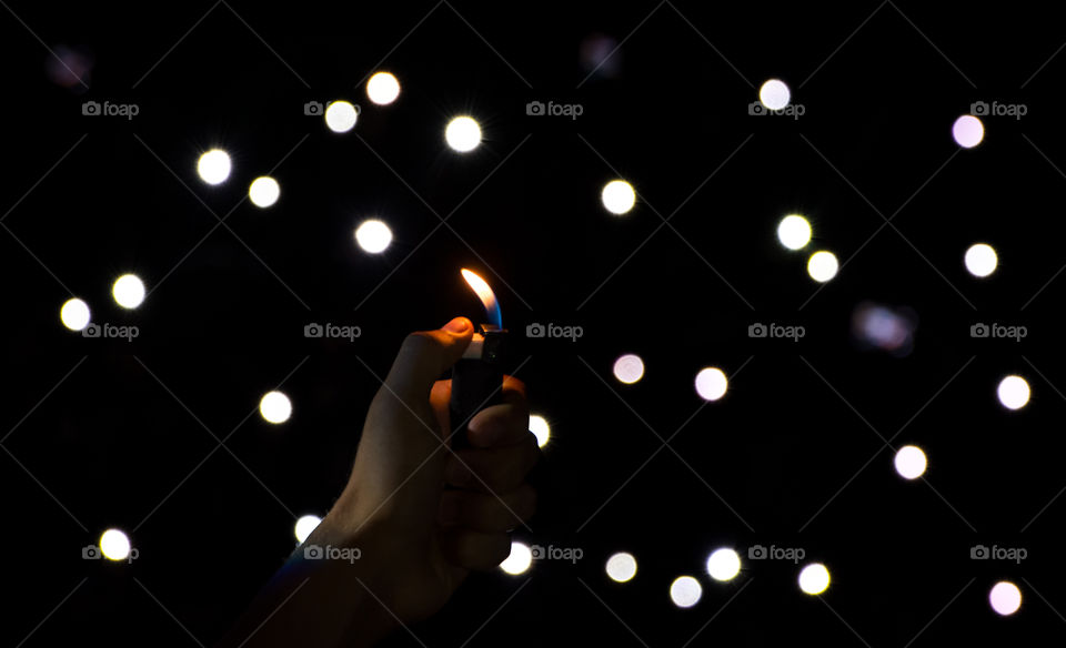 circular lights and hand holding lighter