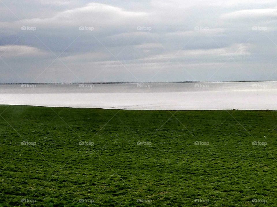 The lakeside grassland is so green, the silverwhite lake is so bright, the sky is a little gray, all of scenery is simple, looks so quiet, peaceful and beautiful. the heart may be cured.