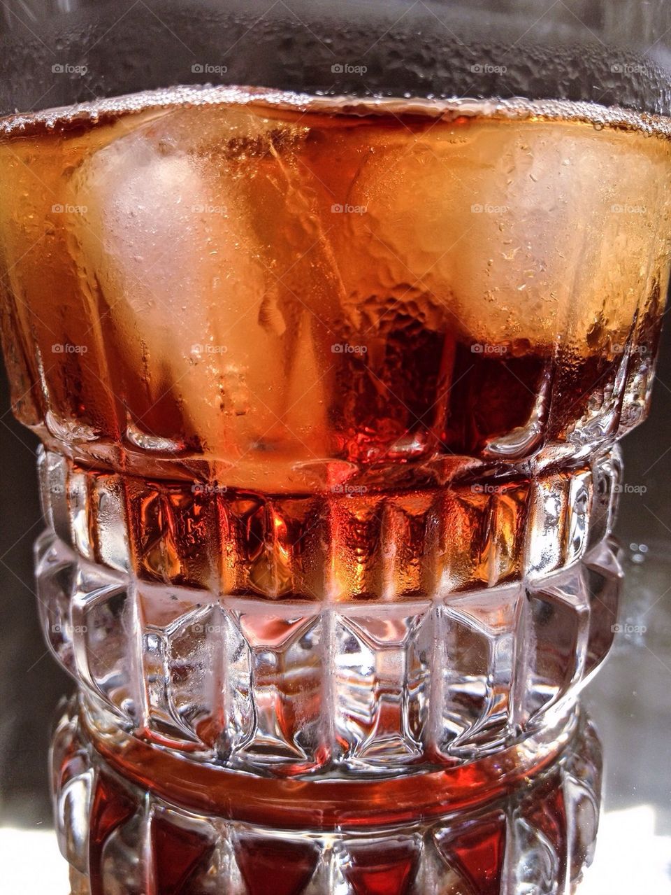 Cola in glass with ice cubes