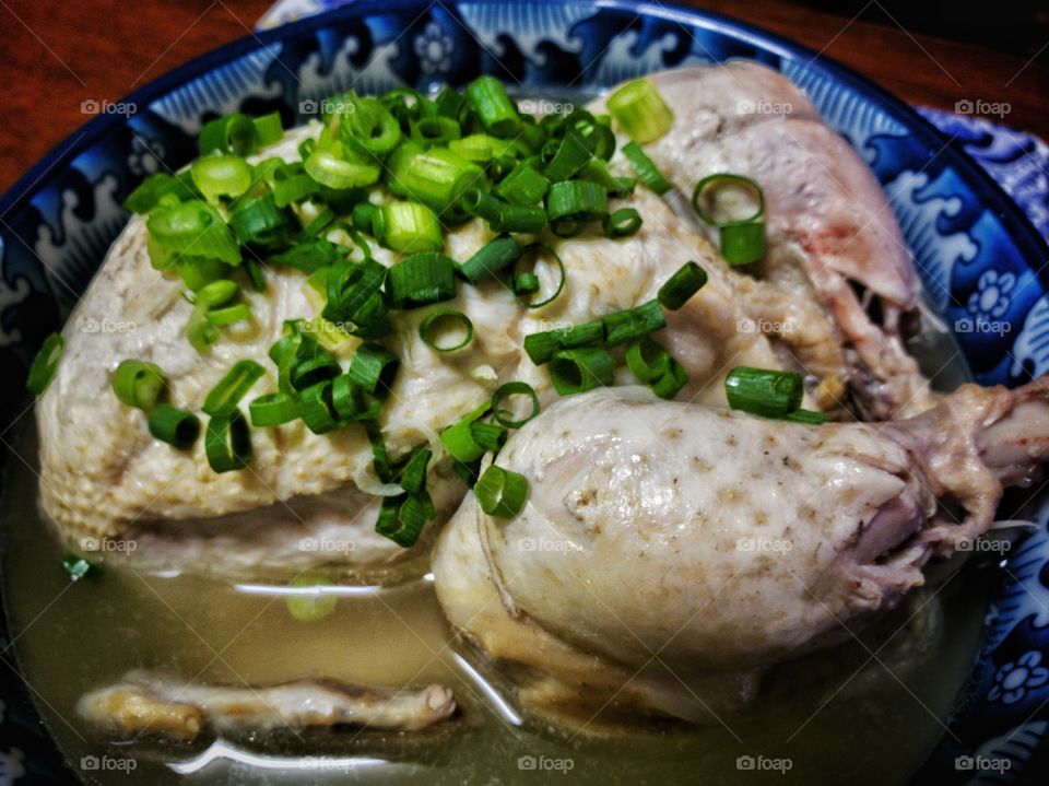 Korean ginseng chicken soup (Samgyetang). Whole young chicken stuffed with ginseng, rice, and jujube, cooked to tenderness and served with chopped green scallions. A traditional soup for general health, especially over the cold winter months.