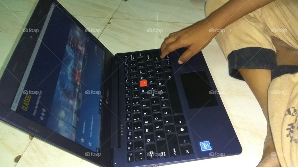 child operating  in laptop playing games