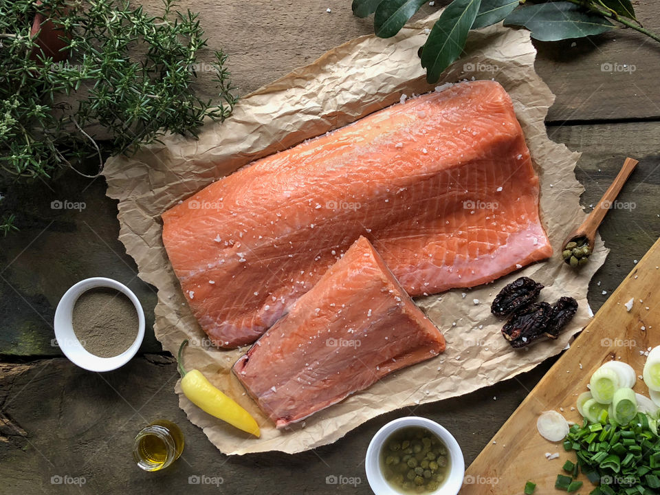 Raw salmon on rustic paper next to their dressings