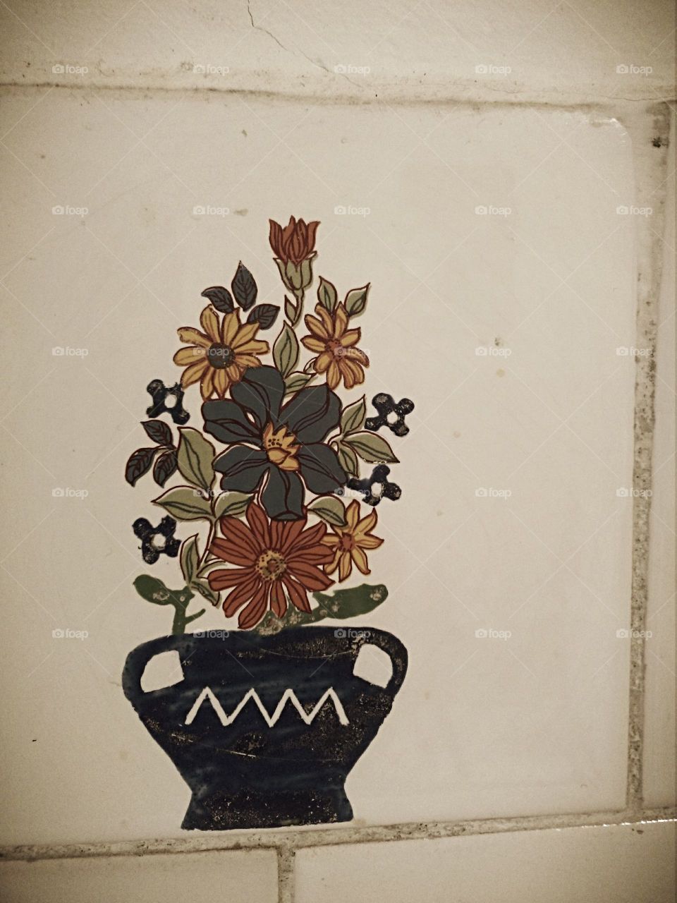 Flowers in a pot on ceramic tiles
