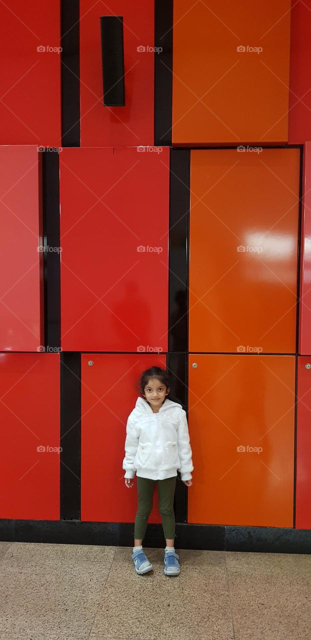 girl infront of rectangle shspe contain wall