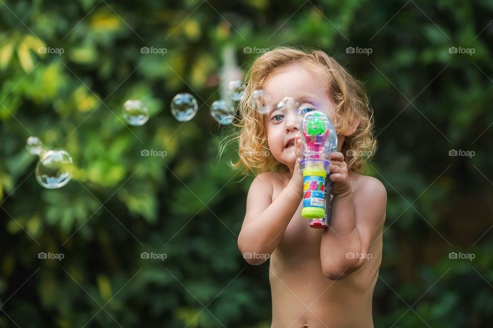 Child playing with bubble gun