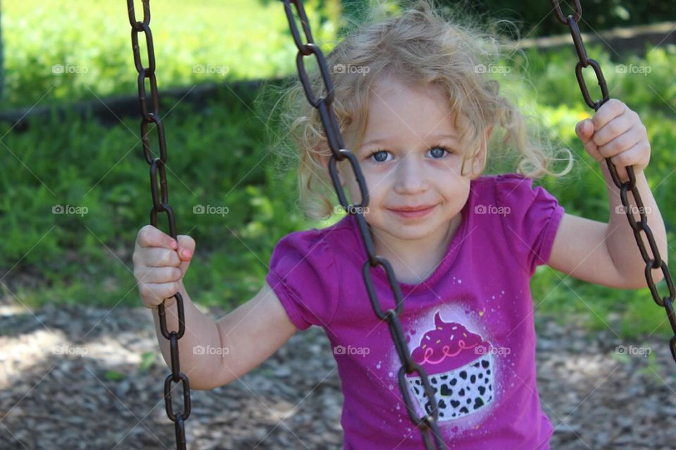 Smiling girl sitting on swing