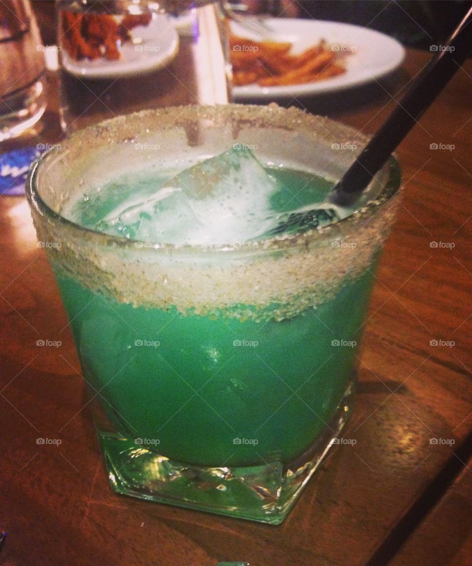 Greenish-blue mixed drink with a salted rim.