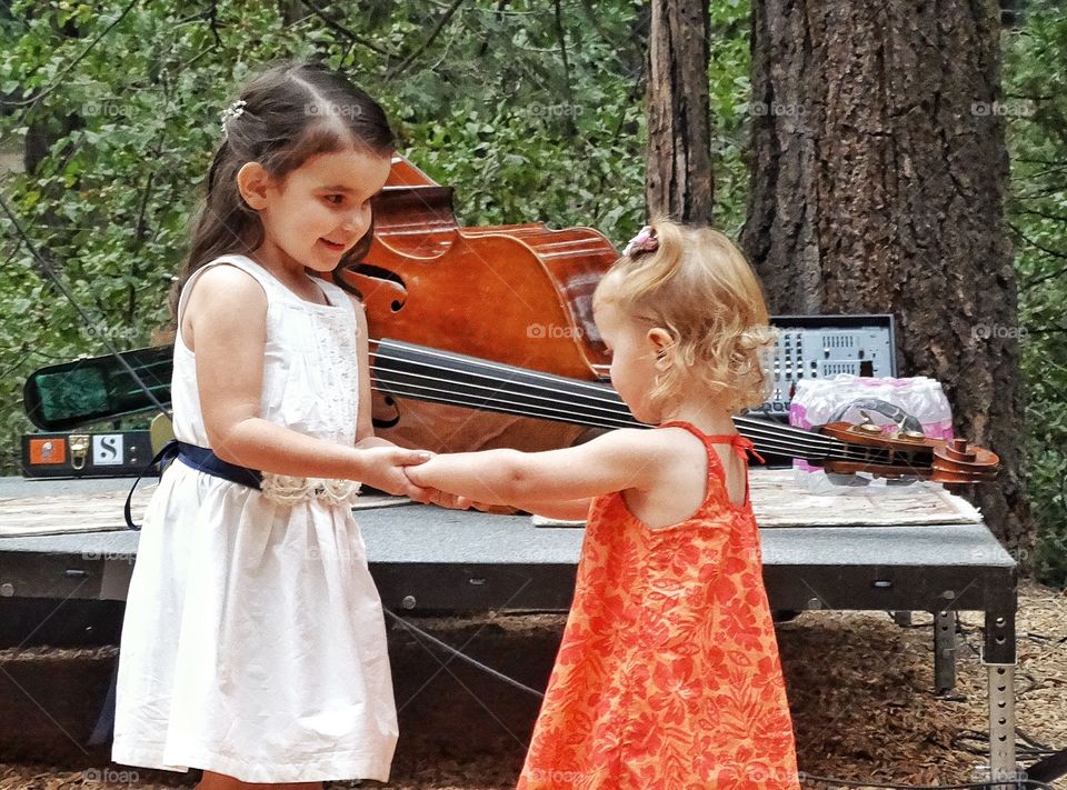 Young Girls Dancing. Toddler Girl And Older Sister Holding Hands On A Dancefloor
