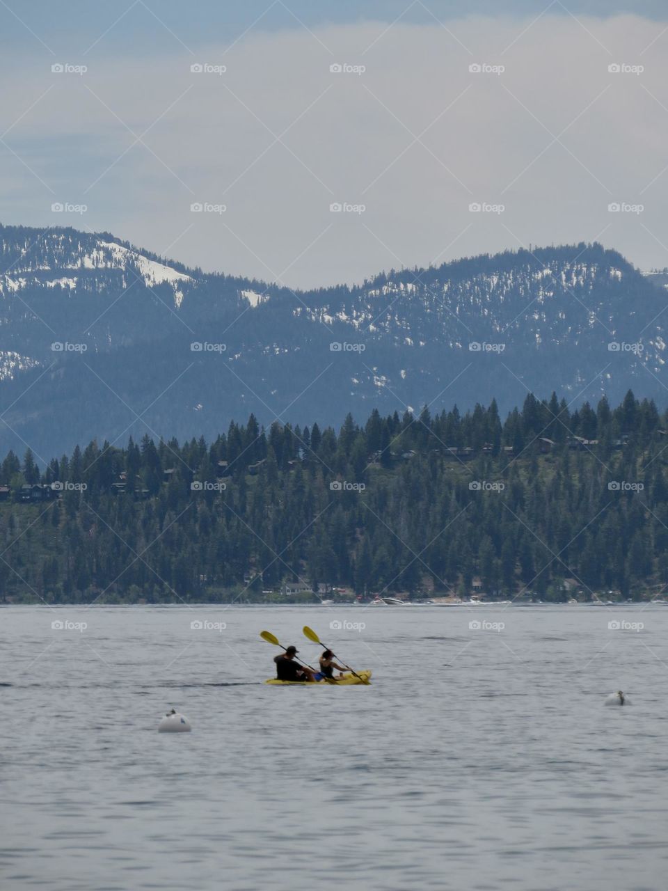 A Yellow Double Kayak on Lake Tahoe Surrounded by Mountains