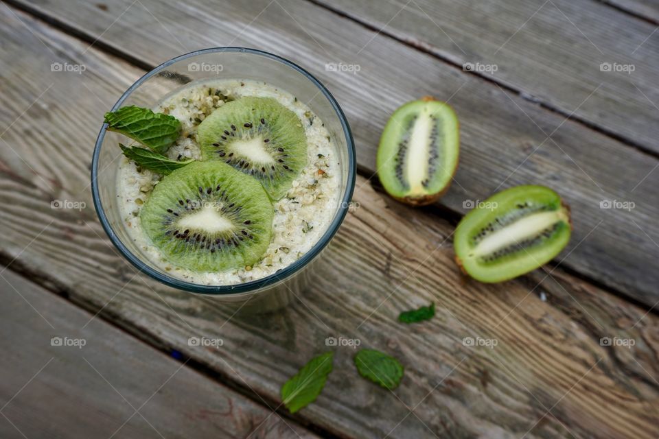 Overhead view of kiwi hemp smoothie on wooden table