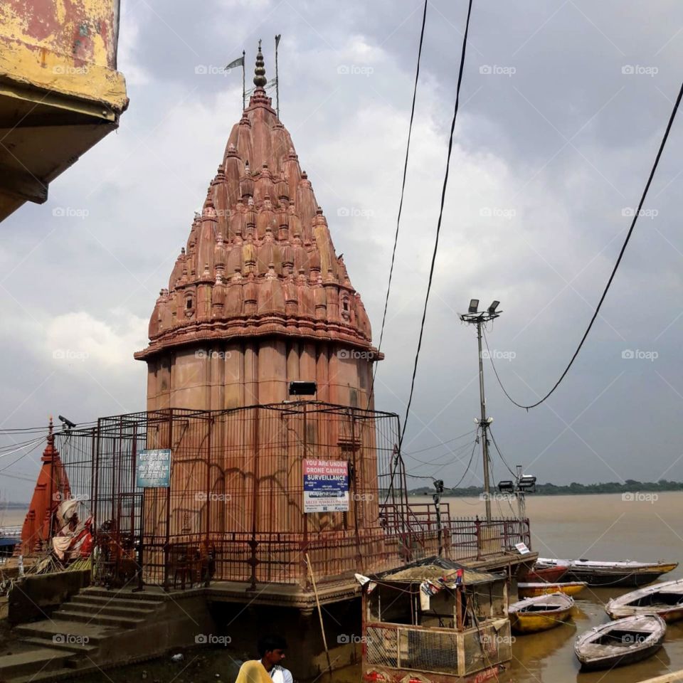 Ancient temple sorrounded with boats near Ganga ghat.
