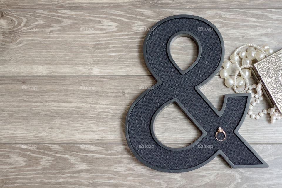 Vintage pearl engagement ring styled on an ampersand with an antique jewelry box and pearls