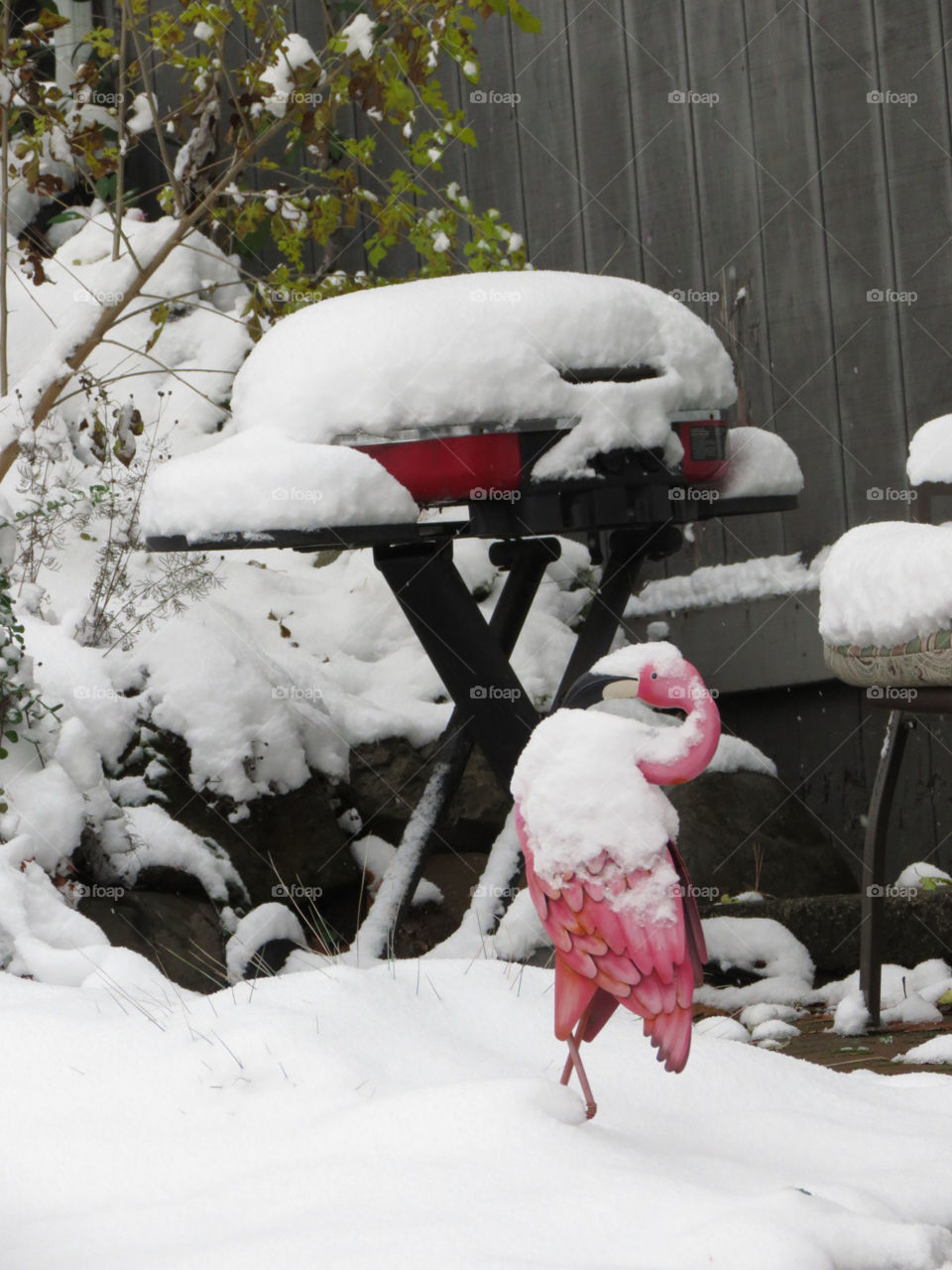 Flamingo and BBQ grill in the snow