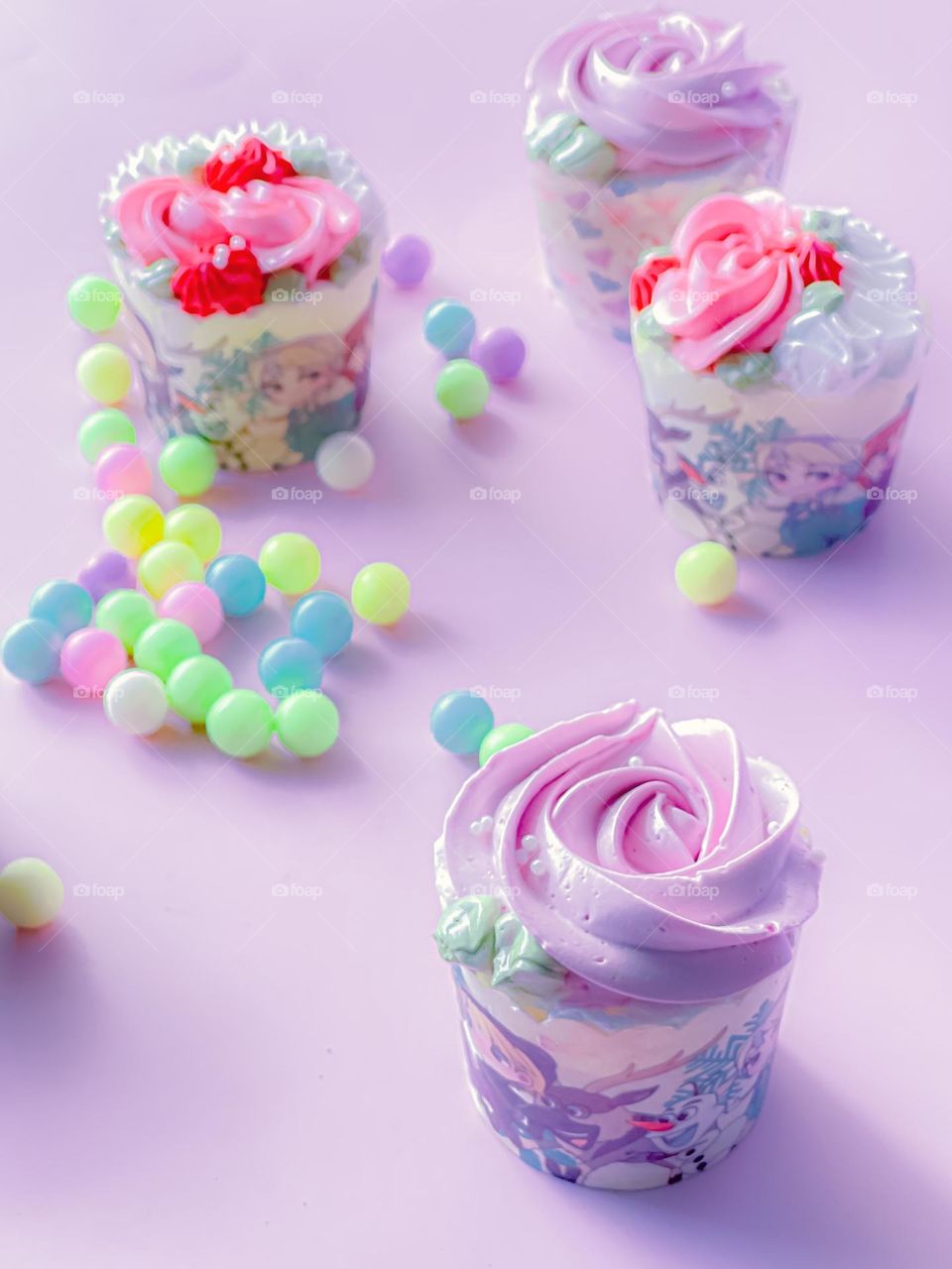 Lavender cupcakes and colourful candies on table top in close up view