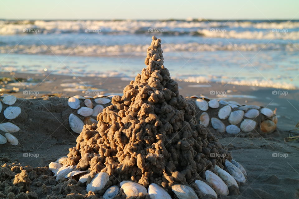 Close Up of a sandcastle with shells in the sunset on the beach of Karlshagen on the German island of Usedom