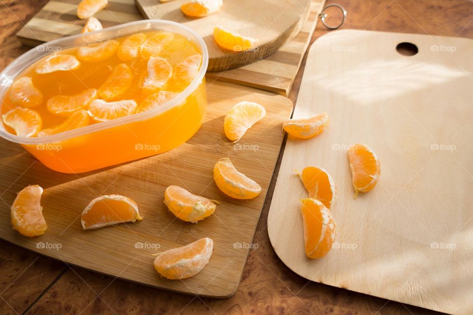 Delicious orange jelly with tangerine slices in a container and jelly worms.