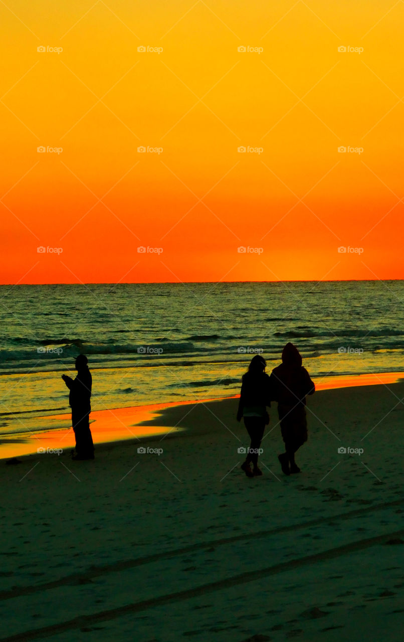 Sunset Surface!
A couple strolls the sandy beach of the Gulf of Mexico as a man looks into the brilliant sunset!