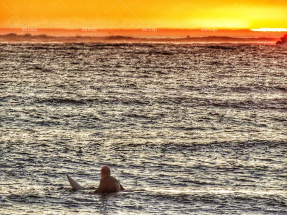 Surfing as the sun sets in Half Moon Bay, California