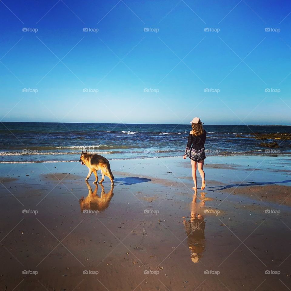 Girl and dog on the beach sunny day