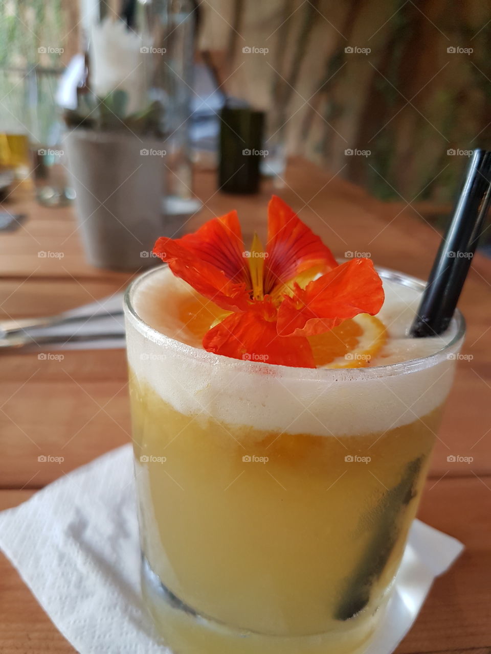 a nicely made cocktail with orange and flower.