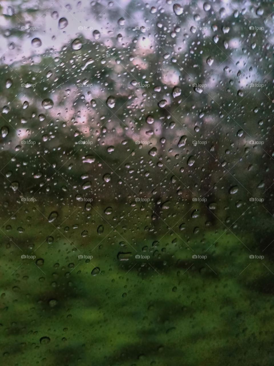 Selective focus on the rain drops on the windshield of the car. After rain at the rainy season