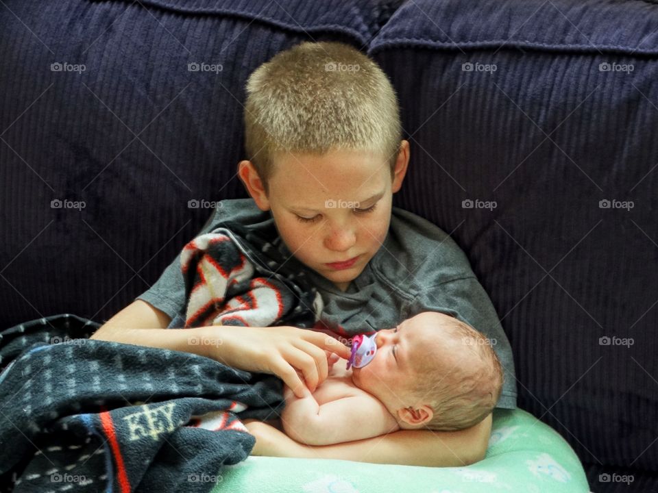 Young Boy Holding His Newborn Sister