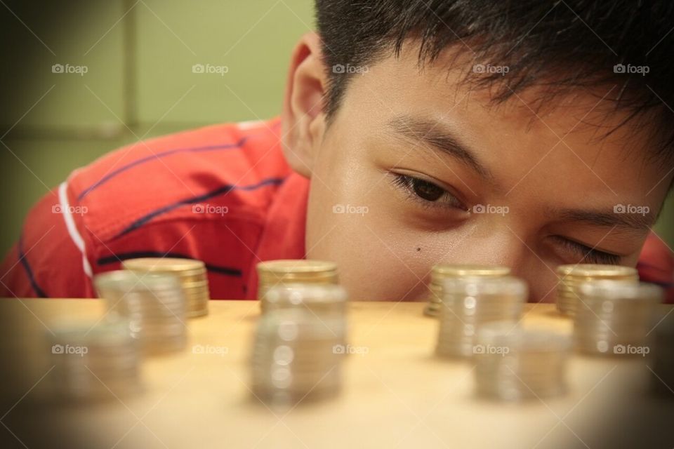 Boy looking at a pile of coins