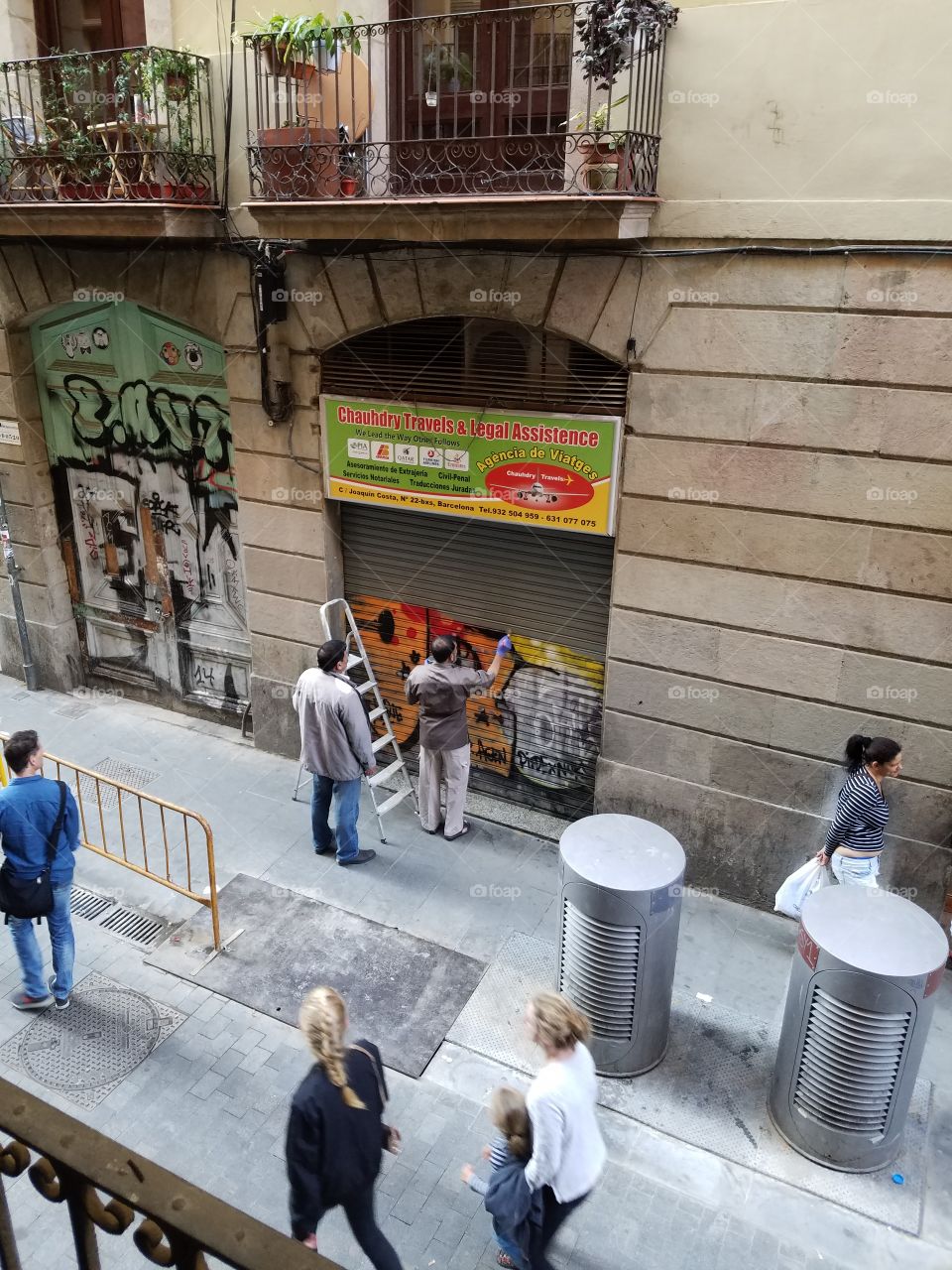 Man painting over graffiti in El Raval, Barcelona