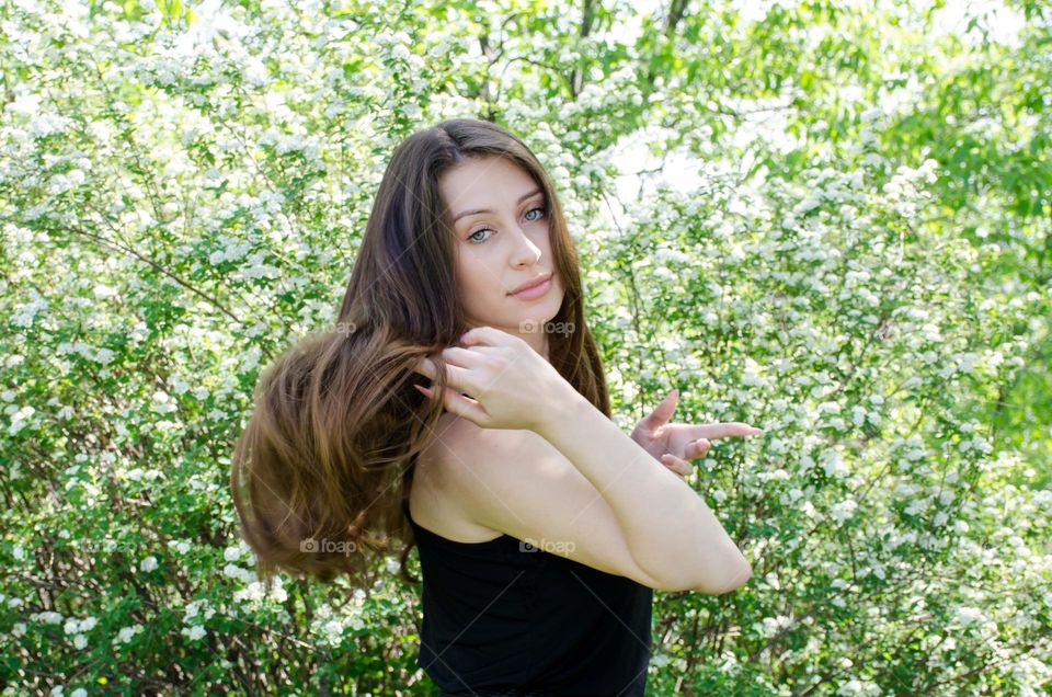 Portrait of a woman brunette on a background of flowers