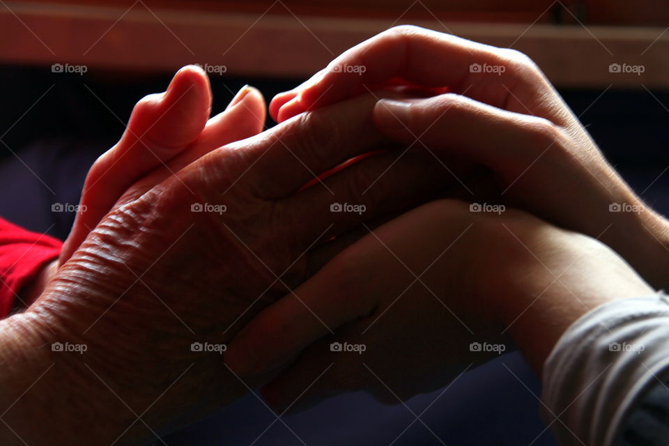 old and young hands embracing together