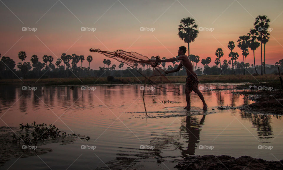 Cambodian fisherman at sunset 