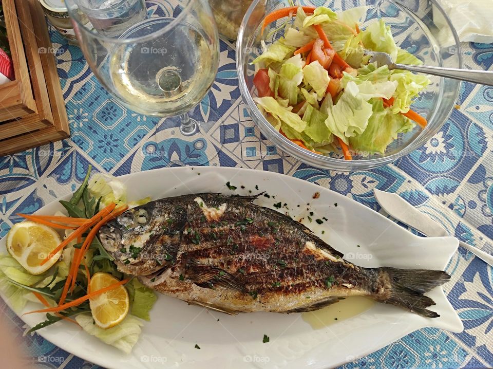 grilled fish with salad and white wine