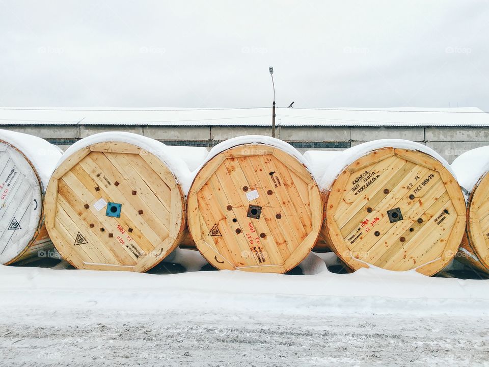 wooden spool of power cables under the snow