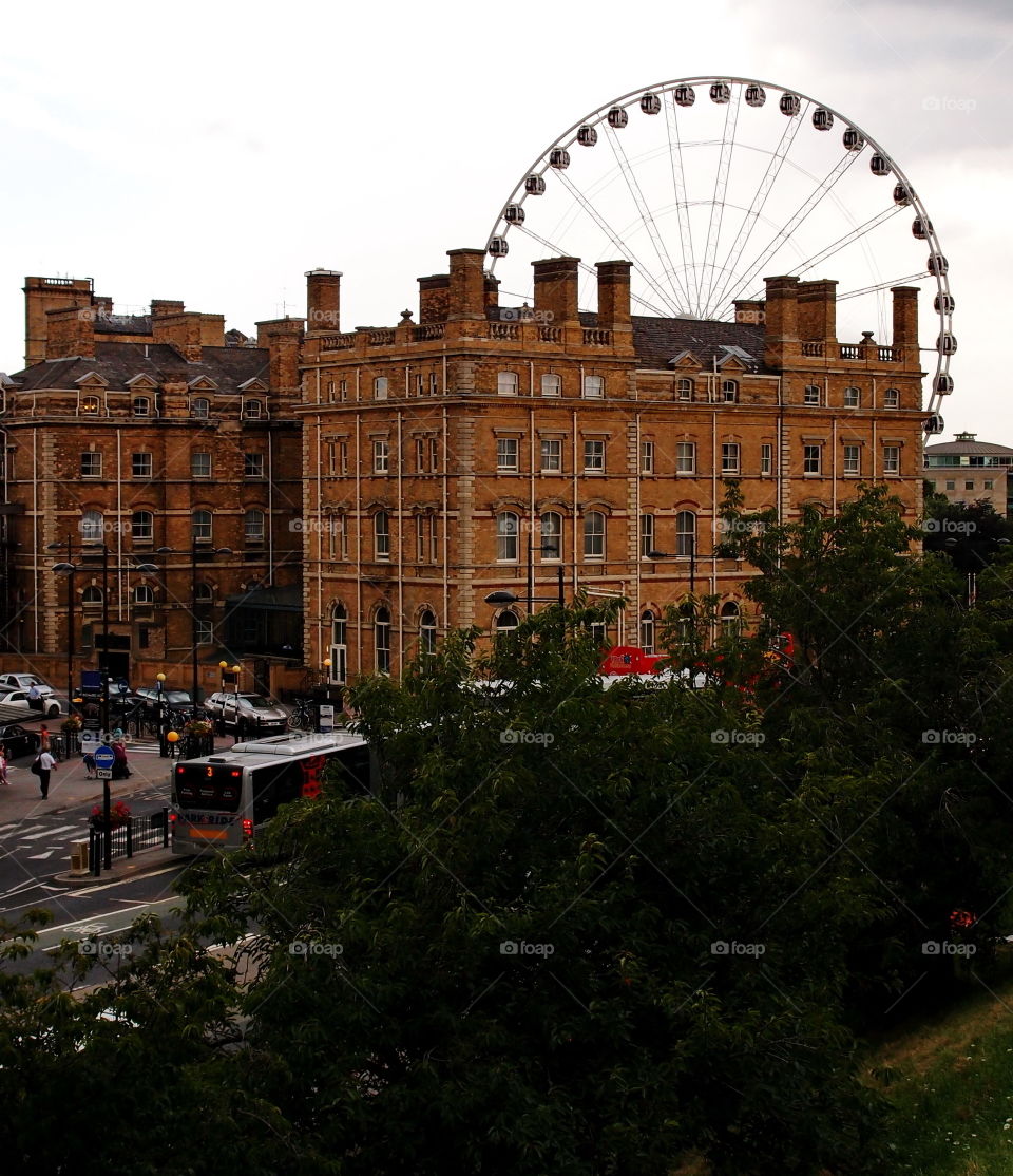 A large old building in front of the York Wheel on summer vacation 