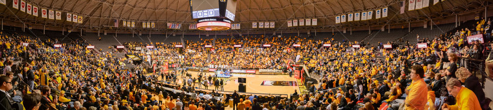 Large panoramic shot of a basketball arena filled with fans. 