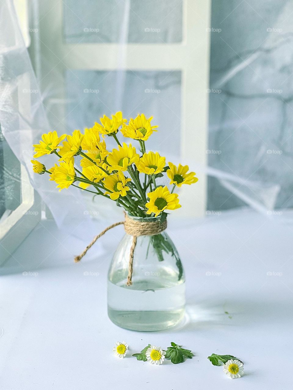Water in a jar for a bouquet of yellow flower with white background 
