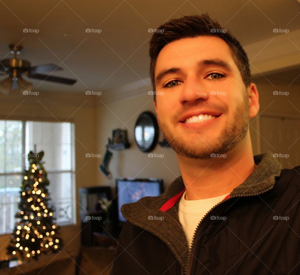 Photo of myself smiling at home during Christmas time.