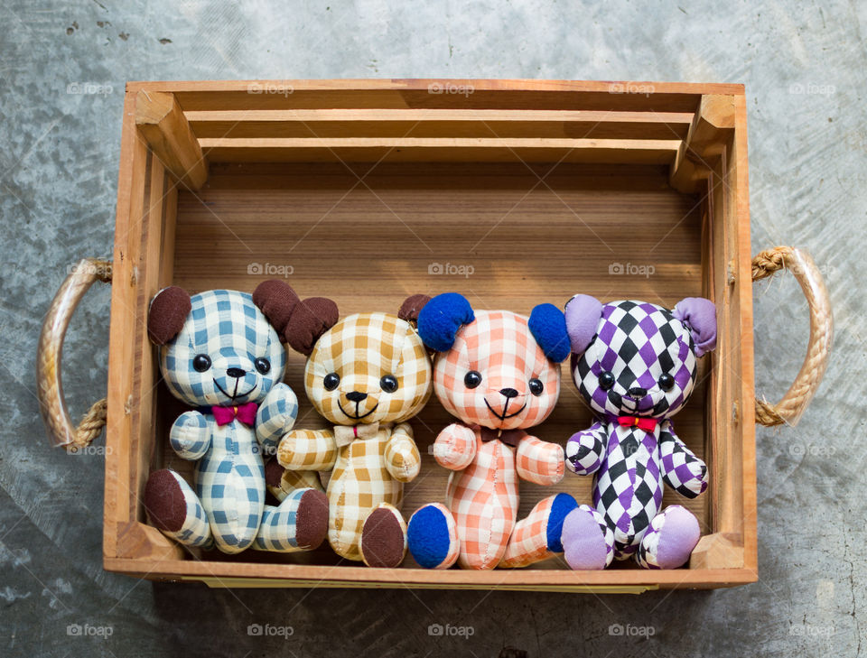 four bear dolls with chessbarred cloth in wood box