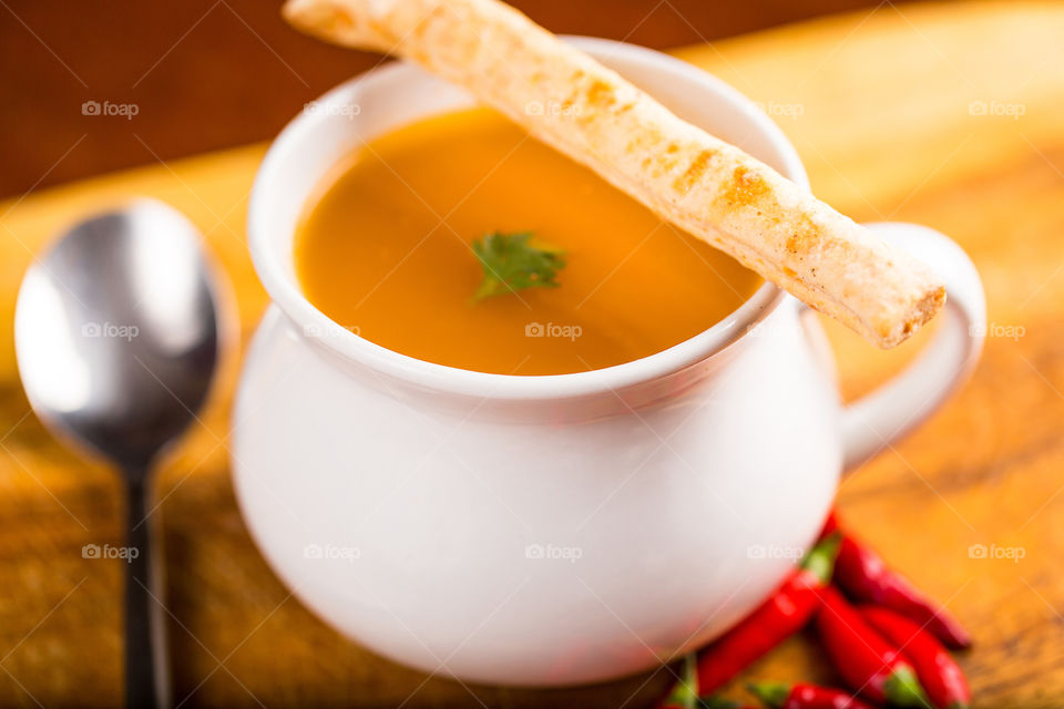 Spicy butternut soup with bread stick. Fresh healthy food. Winter warming chilli and pumpkin soup