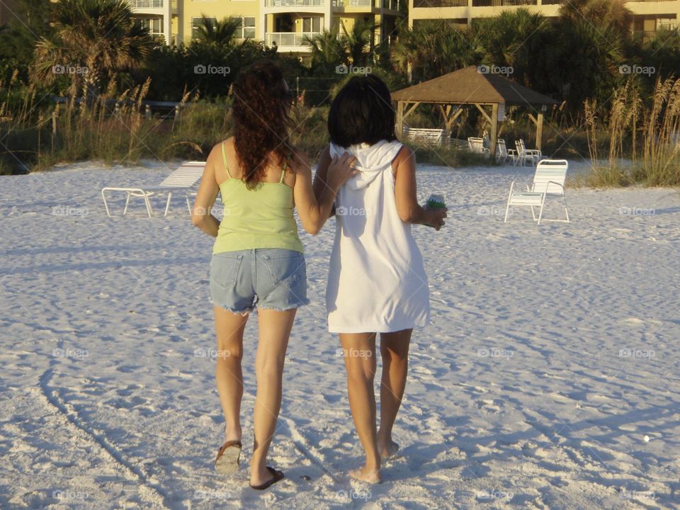 Two friends walking back to lodging after enjoying a day at the beach 