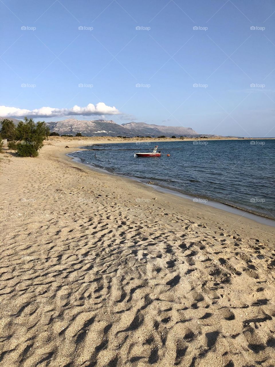 Beach with red fishing boat in the Greek Peloponnese 