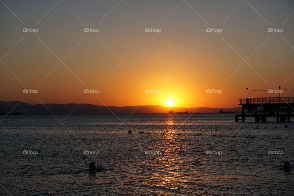 Silhouette of pier at sea during sunset