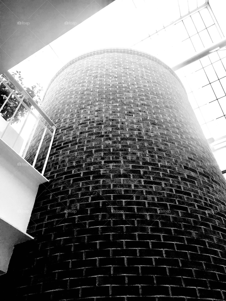 Interesting black and white photo of brick circular column going up towards sky! 