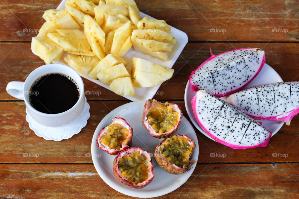 Healthy breakfast with fruits and coffee on table