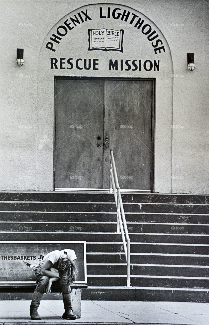 a homeless man waits outside a shelter. homeless. homeless man. by arizphotog